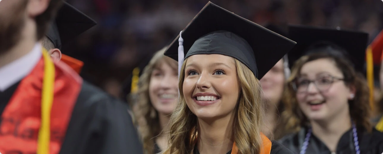 Graduate in cap and gown smiling during a graduation ceremony at Ascencia Malta.