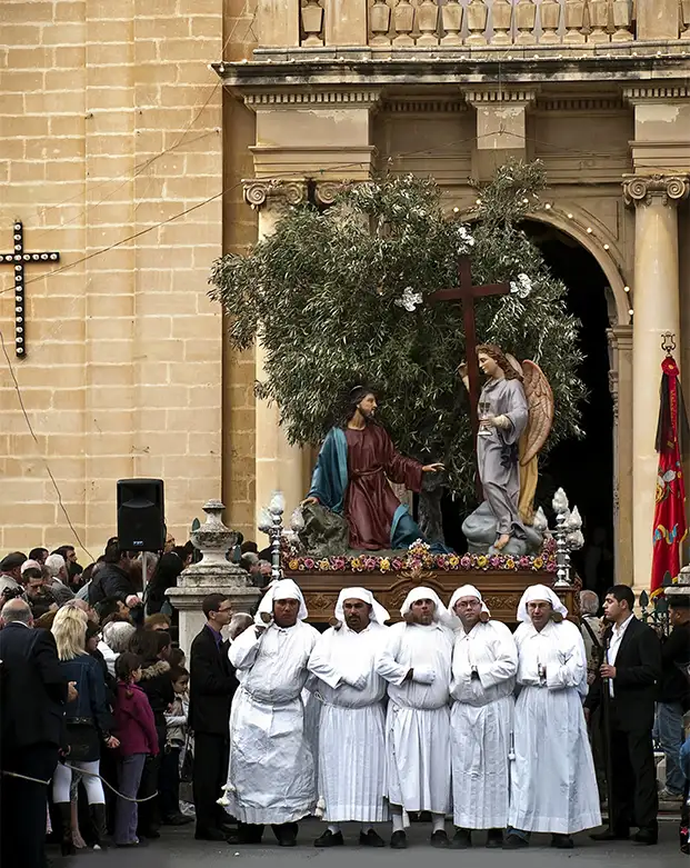 Malta Holy Week religious procession outside historic church with statue, clergy, and traditional Easter celebrations