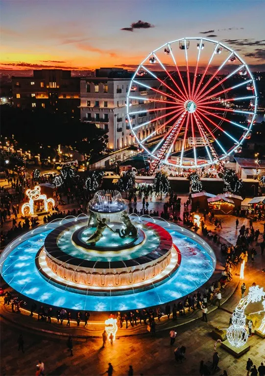 Christmas market in Malta with Ferris wheel and festive lights at night