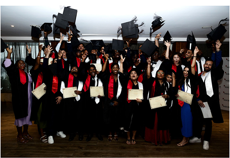 Students celebrating graduation by throwing caps in the air at Ascencia Malta