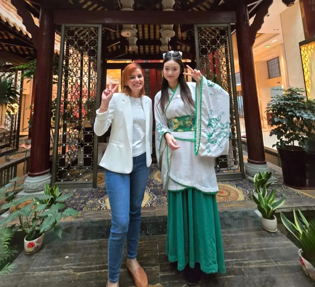 Ascencia Malta team member with student in traditional Chinese attire during cultural visit