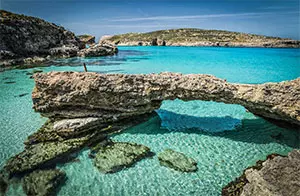 Crystal-clear turquoise waters and natural rock formations at the Blue Lagoon on Comino Island, Malta